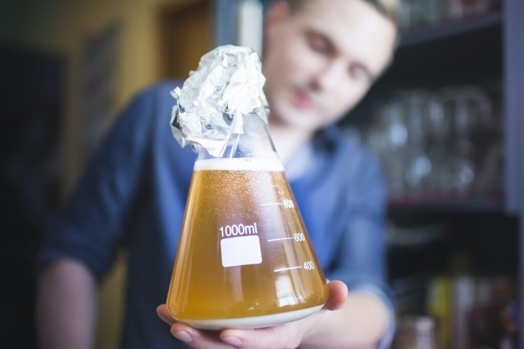 Mid adult man with flask of yeast for home brew beer